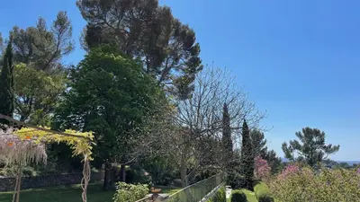 a garden with trees and bushes and a fence at Exclusif Appart piscine chauffée de luxe 10 min centre AixenPc Belvoir SISSI in Aix-en-Provence