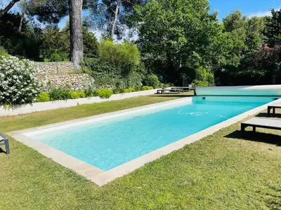 a swimming pool with a bench in the grass at Exclusif Appart piscine chauffée de luxe 10 min centre AixenPc Belvoir SISSI in Aix-en-Provence