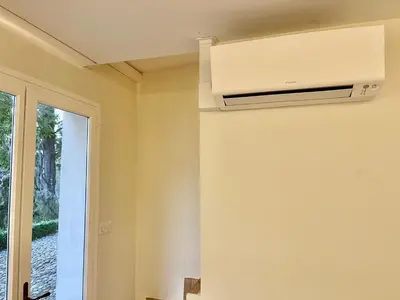a room with a air conditioner on the wall at Exclusif Appart piscine chauffée de luxe 10 min centre AixenPc Belvoir SISSI in Aix-en-Provence
