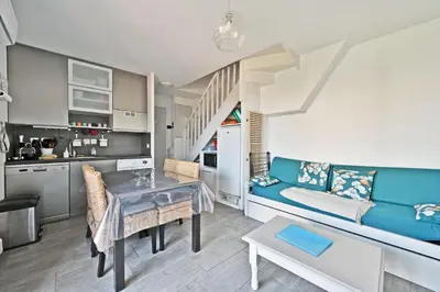 a living room with a blue couch and a table at LE PETIT BONHEUR - PLACE PARKING PRIVEE - CLiM - TERRASSE - PISCINE PARTAGEE - PROCHE PARC SPIROU in Saint-Saturnin-les-Avignon