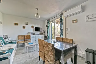 a dining room with a table and chairs and a couch at LE PETIT BONHEUR - PLACE PARKING PRIVEE - CLiM - TERRASSE - PISCINE PARTAGEE - PROCHE PARC SPIROU in Saint-Saturnin-les-Avignon
