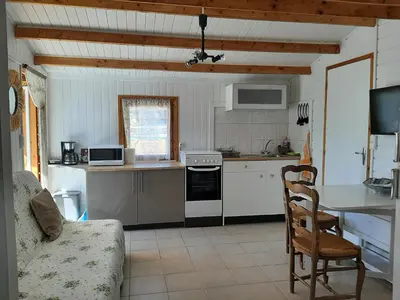 a kitchen with a stove and a couch in a room at Chalet au pied du Mont Ventoux in Mormoiron