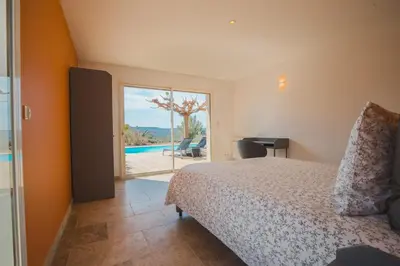 a bedroom with a bed and a view of a pool at LE PETIT CHENE in Apt