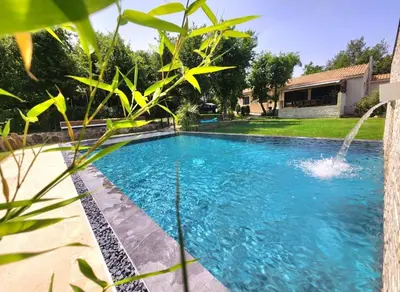 a swimming pool with a fountain in a yard at Maison en provence vue sur le luberon in Maubec