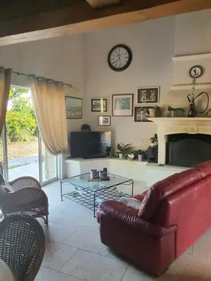 a living room with a couch and a clock on the wall at Villa L'Estagniol in Lourmarin