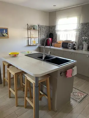 a kitchen with a sink and a table with stools at Proche Saint Rémy de Provence in Mollégès