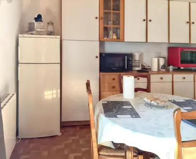 a kitchen with a table and a white refrigerator at Maison de charme à Vachères avec jardin et vue montagne in Vachères
