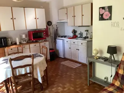 a kitchen with a table and a kitchen with white cabinets at Maison de charme à Vachères avec jardin et vue montagne in Vachères