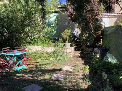 a garden with a table and chairs in the grass at Maison de charme à Vachères avec jardin et vue montagne in Vachères