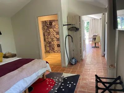a bedroom with a bed and a hallway with a shower at Appart13 piscine chauffée de luxe Belvoir13 à 10 min d Aix in Aix-en-Provence