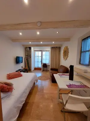 a bedroom with a large bed and a living room at Escapade romantique au cœur du Luberon, Piscine, calme et vue magique in Viens