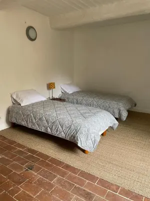 two beds sitting next to each other in a bedroom at Le Petit Egregore, patio et climatisation in Lauris
