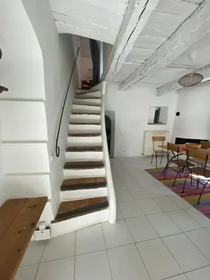 a staircase in a room with a table and chairs at Le Petit Egregore, patio et climatisation in Lauris
