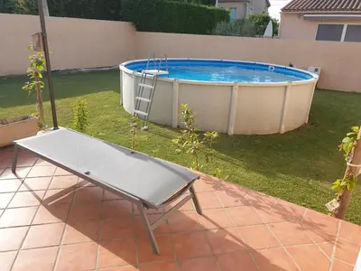 a bench in front of a swimming pool at Petite maison meublée entre Avignon et Carpentras in Morières-lès-Avignon