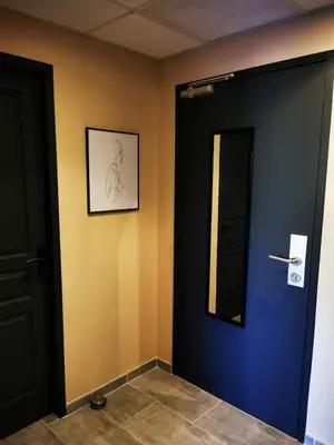 a hallway with a black door and a mirror at Appartement Indépendant dans le Résid hôtel idéal pour les vacances - séminaires - déplacements pro 