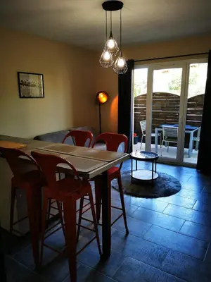 a dining room with a table and chairs and a room with a patio at Appartement Indépendant dans le Résid hôtel idéal pour les vacances - séminaires - déplacements pro 