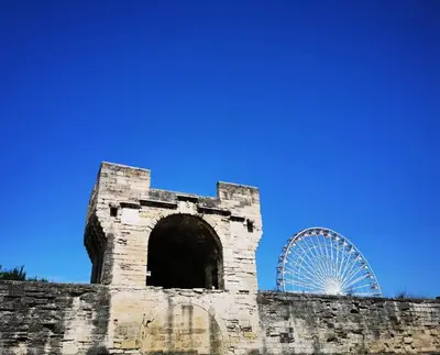 an old building with a ferris wheel in the background at Appartement Indépendant dans le Résid hôtel idéal pour les vacances - séminaires - déplacements pro 