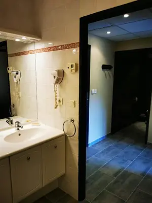 a bathroom with a sink and a shower and a phone at Appartement Indépendant dans le Résid hôtel idéal pour les vacances - séminaires - déplacements pro 