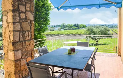 a blue table and chairs on a patio with a view at Nice Home In Lançon-Provence in Lançon-Provence