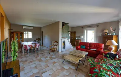 a living room with a red couch and a table at Nice Home In Lançon-Provence in Lançon-Provence