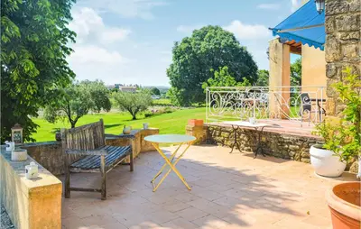 a patio with a table and chairs and a table at Nice Home In Lançon-Provence in Lançon-Provence