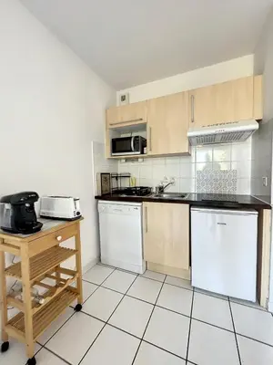 a kitchen with wooden cabinets and white appliances at Casa De Provence in Saint-Saturnin-les-Avignon