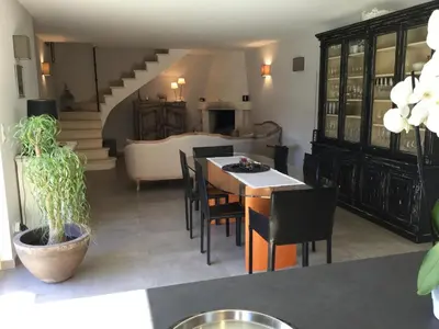 a living room with a table and chairs and a couch at charmante location vacances avec piscine dans les alpilles, à aureille, proche du centre du village à pied- magnifique vue - 6 couchages. in Aureille