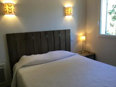a bedroom with a large white bed with two lights at charmante location vacances avec piscine dans les alpilles, à aureille, proche du centre du village à pied- magnifique vue - 6 couchages. in Aureille