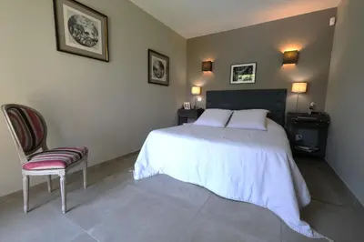 a bedroom with a large bed and a chair at charmante location vacances avec piscine dans les alpilles, à aureille, proche du centre du village à pied- magnifique vue - 6 couchages. in Aureille
