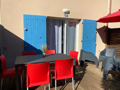a black table with red chairs and blue doors at Bastidon les Demeures du Ventoux in Aubignan