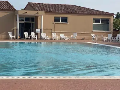 a swimming pool with chairs and a house at Bastidon les Demeures du Ventoux in Aubignan