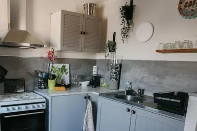 a kitchen with white cabinets and a sink and a stove at Provence Now in Cabrières-dʼAvignon