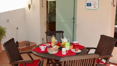 a table with food on a red table cloth at Gîte L'Escapade in Saint-Saturnin-les-Apt