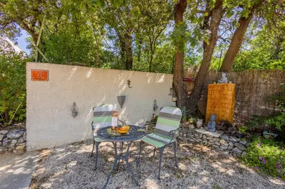 a table and chairs in a backyard with a fence at Gîte L'Escapade in Saint-Saturnin-les-Apt