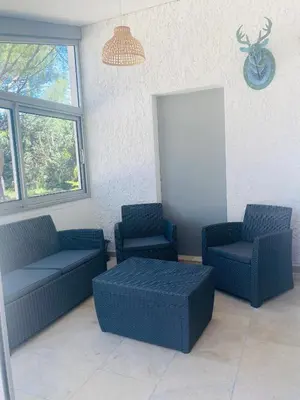 a waiting room with two blue chairs and a table at La Maison d à côté 8 à 10 personnes in Carpentras