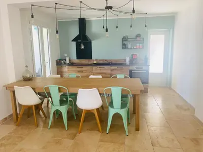 a dining room with a wooden table and chairs at La Maison d à côté 8 à 10 personnes in Carpentras