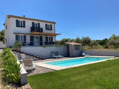 a villa with a swimming pool in front of a house at La bastide in Malemort-du-Comtat