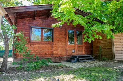 a log cabin with a porch and a tree at Gîte sous le Tilleul, Luberon in Croagnes