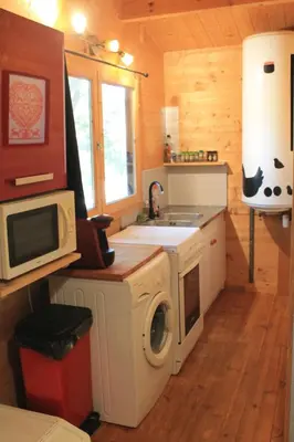 a kitchen with a washing machine and a microwave at Gîte sous le Tilleul, Luberon in Croagnes