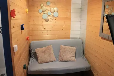 a couch in a room with a wooden wall at Gîte sous le Tilleul, Luberon in Croagnes