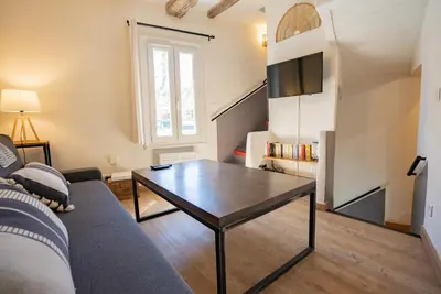 a living room with a couch and a table at Petite maison de charme au cœur du centre ville in Apt