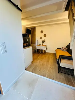 a kitchen and a living room with a table at Maisonnette avec terrasse privée au calme absolu - proche LOURMARIN in Cadenet
