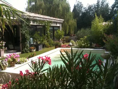 a garden with a swimming pool and flowers at Le Clos Martin in Eyragues