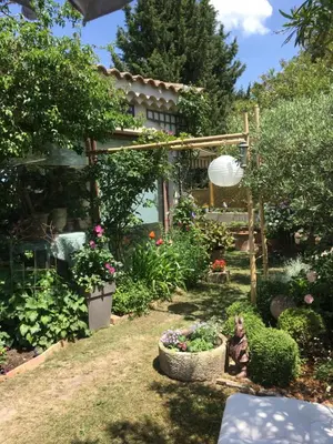 a garden with flowers and a statue in the yard at Le Clos Martin in Eyragues