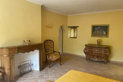 a living room with a chair and a fireplace at Propriété d'exception au coeur du Luberon in Robion en Luberon
