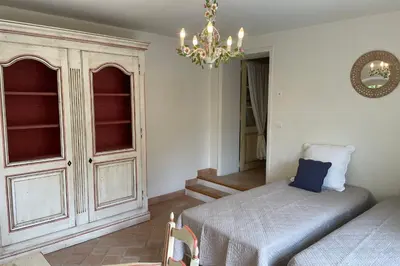 a bedroom with a bed and a chandelier at Propriété d'exception au coeur du Luberon in Robion en Luberon