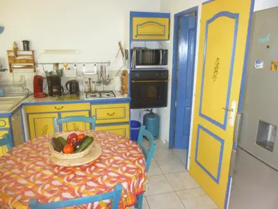 a kitchen with a table with a bowl of fruit on it at PROVENCE SOLEIL LUBERON PISCINE in Apt