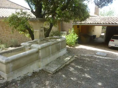 a stone fountain in front of a house at PROVENCE SOLEIL LUBERON PISCINE in Apt