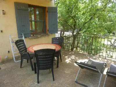 a patio with a table and chairs on a balcony at PROVENCE SOLEIL LUBERON PISCINE in Apt
