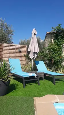 two blue chairs and an umbrella next to a pool at OUSTAOU DU GAYET gîte de charme avec piscine privée in Lourmarin